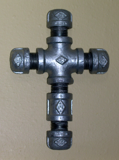 Cross made from iron pipe fittings hangs on the wall over my door.