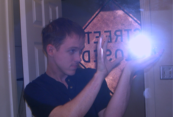 Self-portrait taken in bathroom mirror with camera flash positioned to create 'magic energy ball' effect.  This one has been slightly blue-shifted in Photoshop.