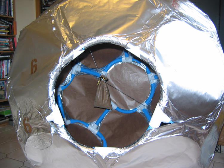 View through the access port reveals underlayer of brown paper.