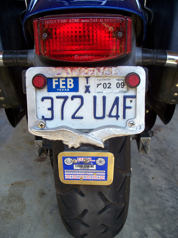 Homemade sand cast license plate frame from scrap aluminum with eagle motif below and name, LAWRENCE, above.