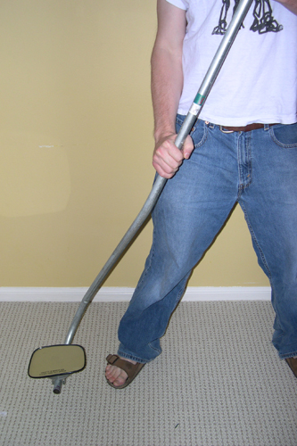 The mirror assembly is clipped to the bent conduit handle, and the complete tool used from a standing position to inspect the undercarriage of an automobile.